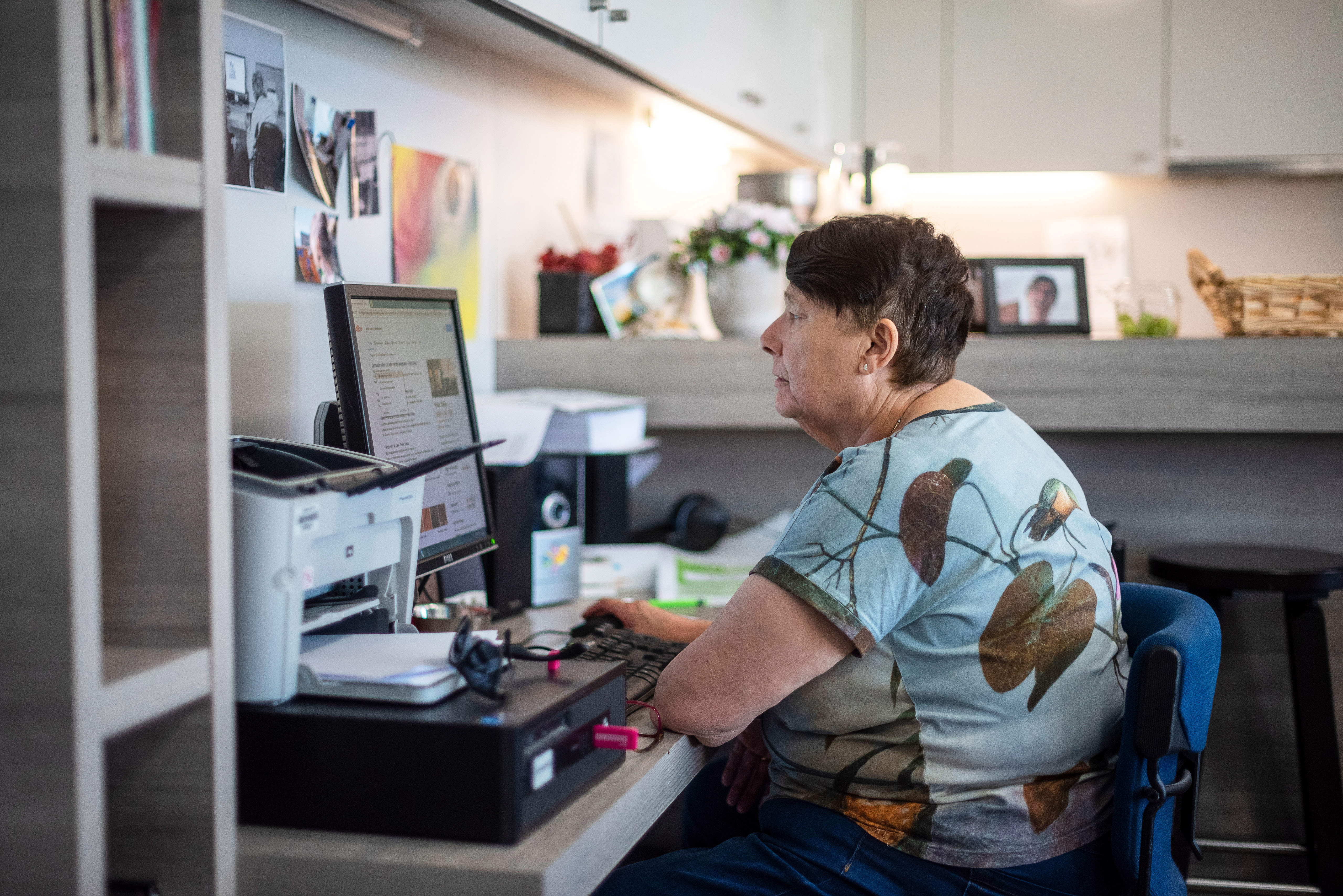 Vrouw aan computer in ontmoetingshuis Aliado
