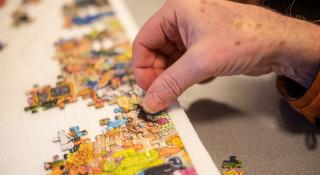 Hand dat aan een puzzel werkt