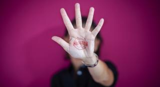Paarse achtergrond met vrouw die hand omhoog houdt en stigWA-stempel