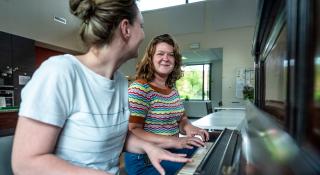 Medewerkers van Steiger aan de piano