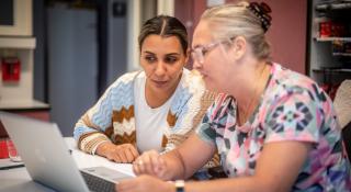 Twee mensen die samen naar een computerscherm kijken