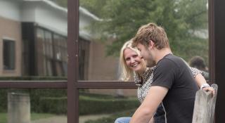 Twee mensen in gesprek buiten op de bank