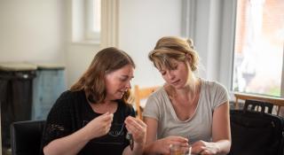 Twee personen werken samen aan een halsketting