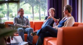 Drie personen in gesprek in het hop-gebouw