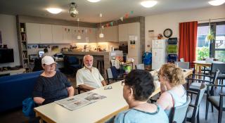 Mensen in gesprek in ontmoetingshuis Aliado