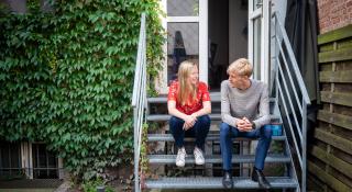 Man en vrouw met elkaar in gesprek op de trap