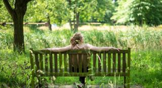 Vrouw op bank op prachtig groene domein van Elim