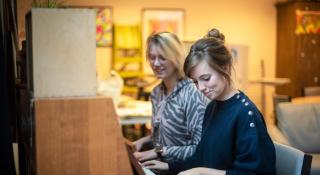 Twee vrouwen spelen samen piano