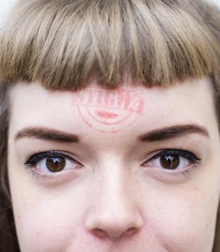 Jonge vrouw met stigWA-stempel op voorhoofd