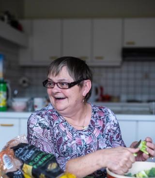 Een vrouw is aardappelen aan het schillen