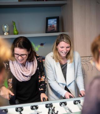 Groepje mensen spelen tafelvoetbal