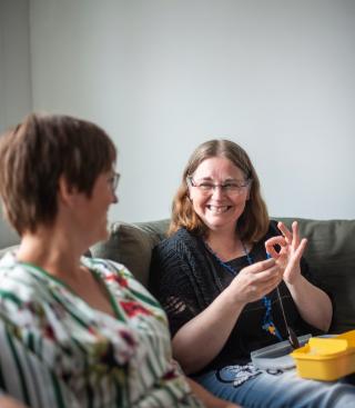 Twee vrouwen doen een praatje in de zetel