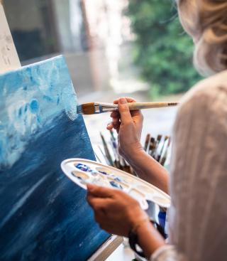 Vrouw schildert tijdens beeldende therapie