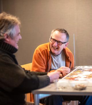 Twee mannen maken samen een puzzel