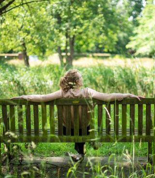 Vrouw op bank op prachtig groene domein van Elim