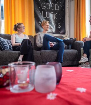 Drie personen voeren een gesprek in de zetel