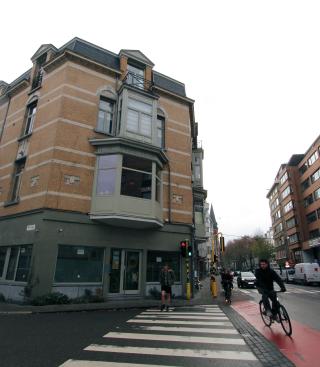 huis in straat met voorbijrijdende fietser