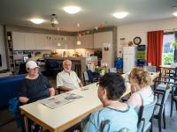 Mensen in gesprek in ontmoetingshuis Aliado