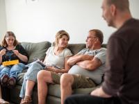 Mensen zitten samen in het salon van ontmoetingshuis Kompas